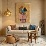 African American art with gold accents in living room with warm plaster walls, brass pendant, African sculpture, Moroccan rug. Digital mockup.