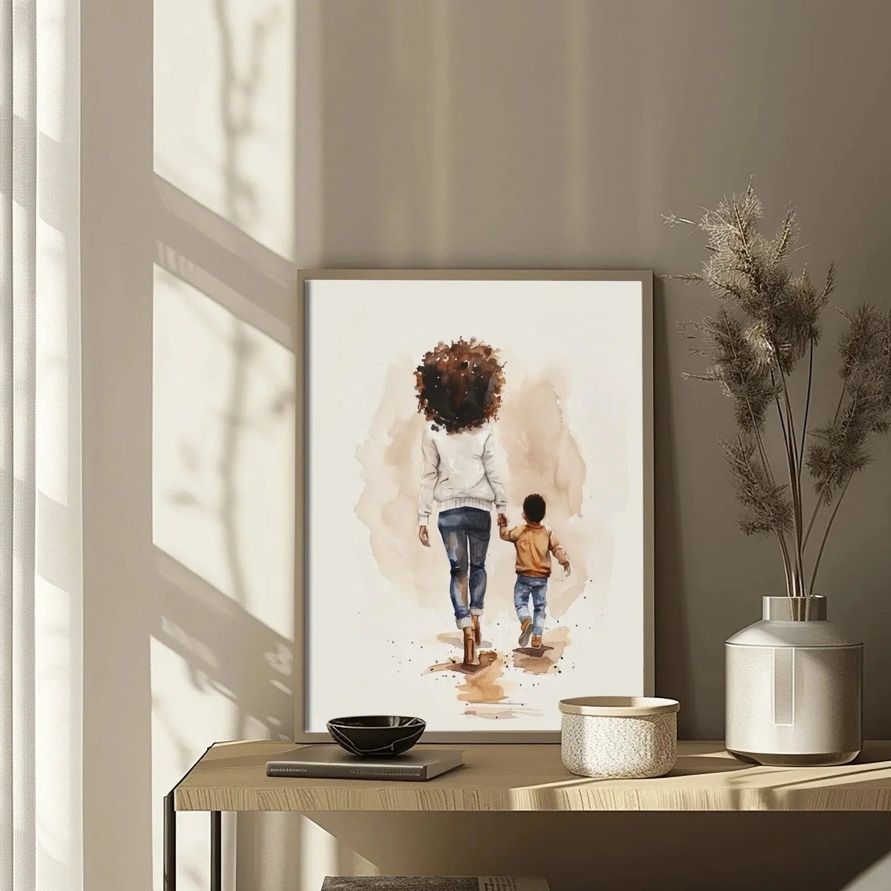 Black motherhood nursery wall art detail of artwork on rustic console with pampas, watercolor Black mother walking with son. Digital mockup.