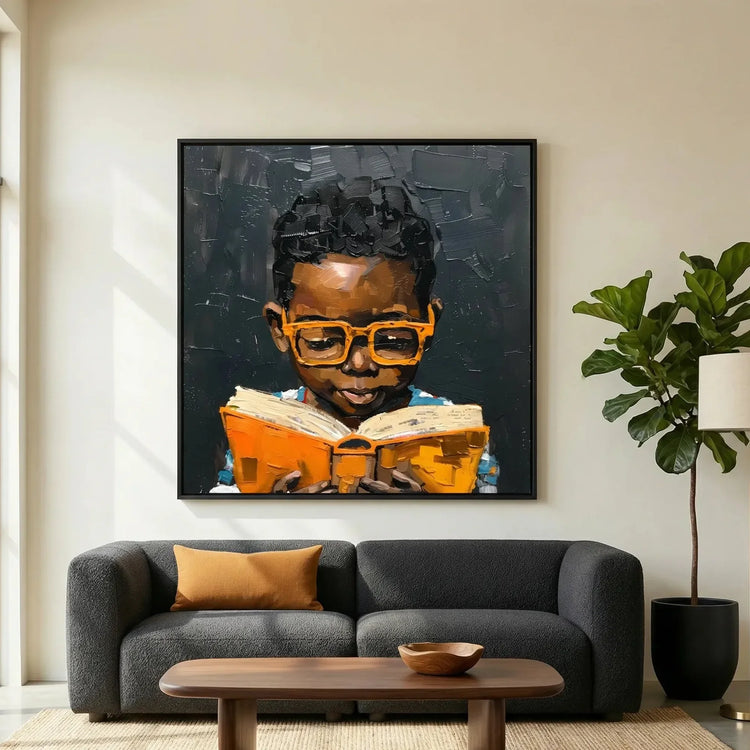 Modern African American art in modern living room with charcoal sofa and fiddle leaf, Black boy in orange glasses reading. Digital mockup.