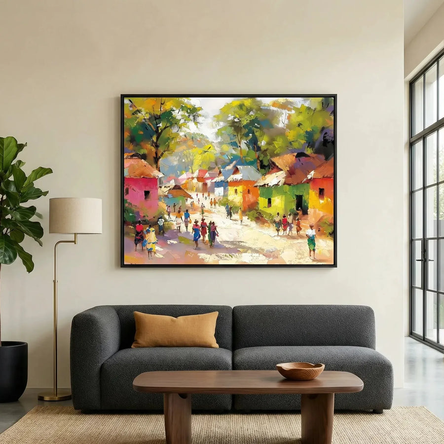African landscape paintings in modern living room with charcoal sofa and fiddle leaf, colorful African village scene painting. Digital mockup.